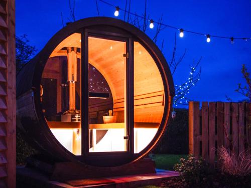 a circular building with a window in a yard at night at Bailey Huts in Litton