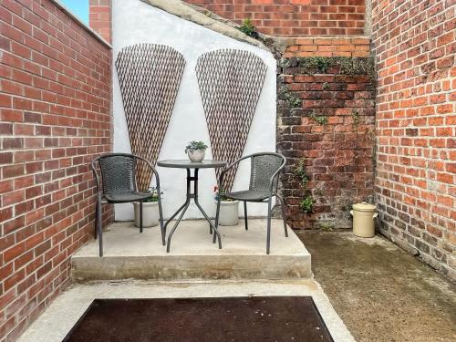 a patio with two chairs and a table in a brick wall at The Salthouse in Sunderland