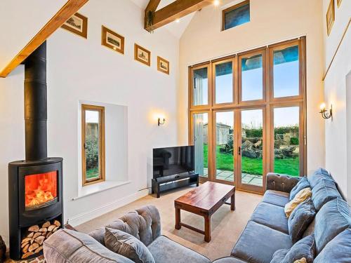 a living room with a couch and a fireplace at Knoll View Ranch in Shepton Mallet