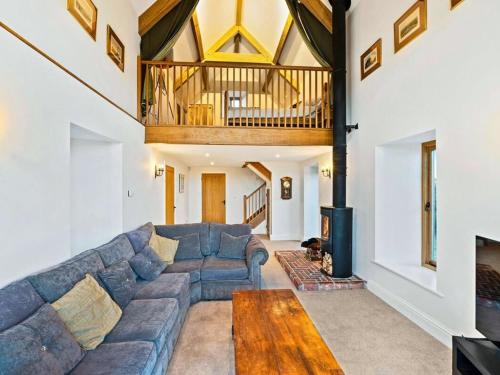 a living room with a blue couch and a wooden table at Knoll View Ranch in Shepton Mallet