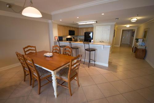 a kitchen and dining room with a table and chairs at Escapes! To The Shores Orange Beach, A Ramada by Wyndham in Orange Beach