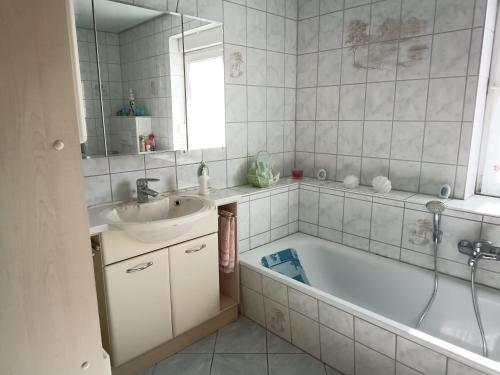 a bathroom with a sink and a tub and a mirror at Ferienwohnung Alte Post in Knorrendorf