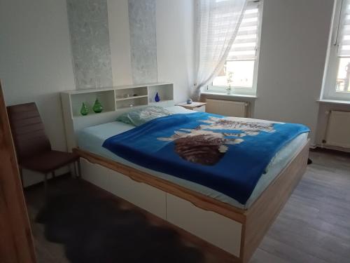 a bedroom with a bed with a blue blanket at Ferienwohnung Alte Post in Knorrendorf