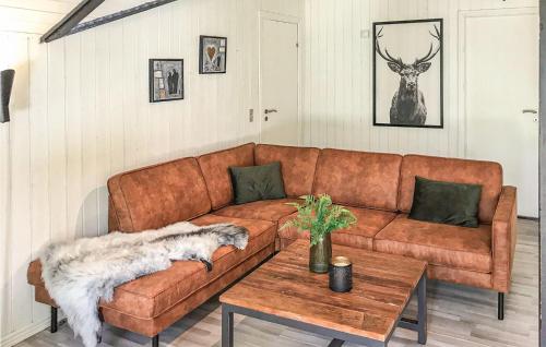 a living room with a brown couch and a table at Holiday Home Østmarken Toftlund Denm in Toftlund