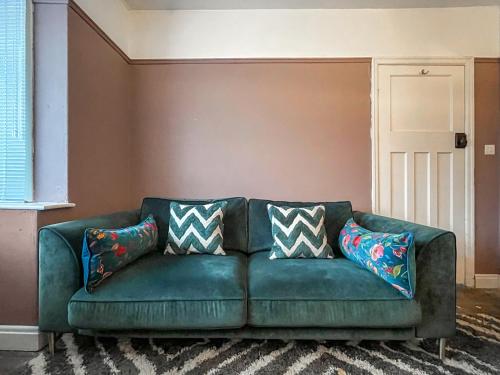 a green couch in a living room with pillows on it at Longshore in Runswick
