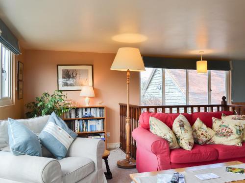 a living room with a red couch and a table at Bugatti House in Bosbury