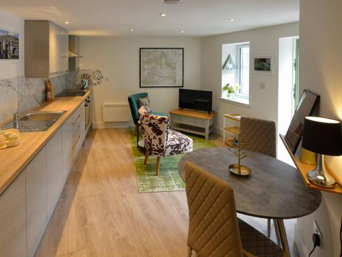 a kitchen with a table and a living room at Hope Cottage - Uk40055 in Aberfeldy