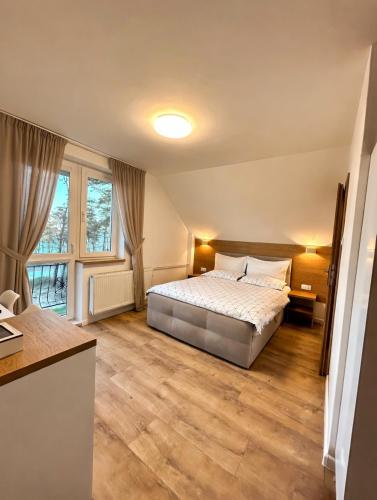 a bedroom with a bed and a large window at „Amber” Pokoje z widokiem na morze in Krynica Morska