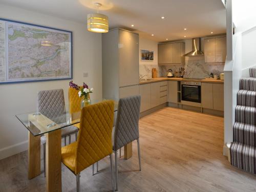 a kitchen and dining room with a glass table and chairs at Harris Cottage - Uk40056 in Aberfeldy