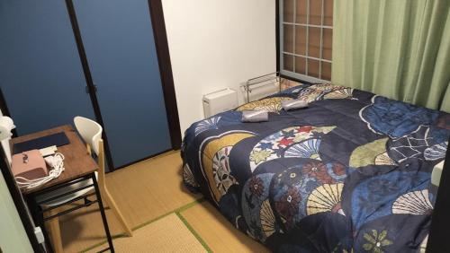 a bedroom with a bed with a quilt on it at 103個室元芸者の隠れ宿湯河原 in Yugawara