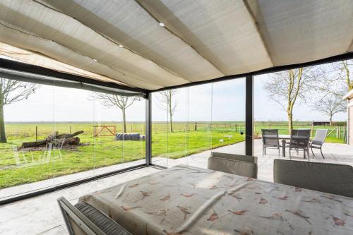 a bedroom with a view of a field through windows at t Huysje van Klippel in Tholen