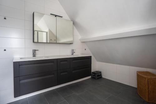 a bathroom with a sink and a mirror at t Huysje van Klippel in Tholen