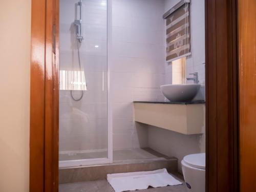 a bathroom with a shower and a sink and a toilet at Captain Residency Hotel in Lagos
