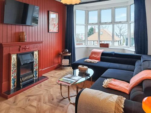 a living room with a blue couch and a fireplace at The Lobster Pot in Shotley Gate
