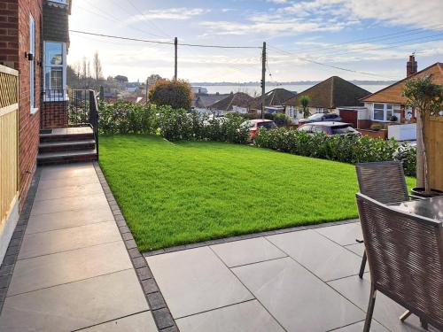 a patio with a lawn and a yard with chairs at The Lobster Pot in Shotley Gate