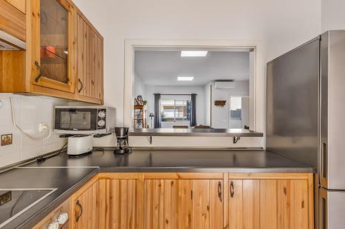 a kitchen with wooden cabinets and a stainless steel refrigerator at Memorable Holidays With Your Family in Maspalomas