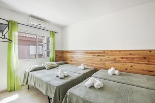 two beds in a room with green curtains at Memorable Holidays With Your Family in Maspalomas