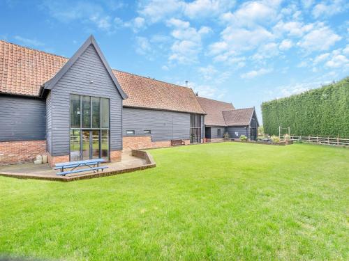 a house with a large yard with a grass field at Clamp Farm Barn in Stowmarket