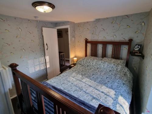 a bedroom with a bed with a blue comforter at River Cottage in Llanbedr