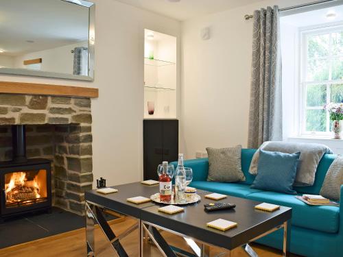 a living room with a blue couch and a fireplace at Waterloo Farm House in Bankfoot