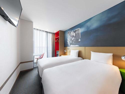 a hotel room with two beds and a tv at ibis Styles Ambassador Seoul Myeong-dong in Seoul