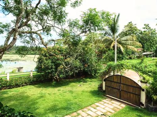 a garden with a gate and a fence at Spacious 2 Bedroom Apartment with Lake View in Tangalle