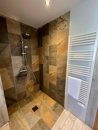 a bathroom with a shower with a glass door at L'échappée in Neulliac