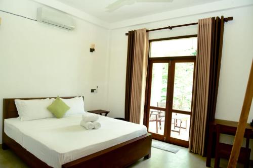 a bedroom with a bed with a teddy bear on it at Abey Villa Madiha Beach Surf Stay in Matara