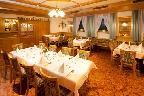 une salle à manger avec des tables et des chaises blanches dans l'établissement Landhotel-Gasthof-Schreiner, à Hohenau