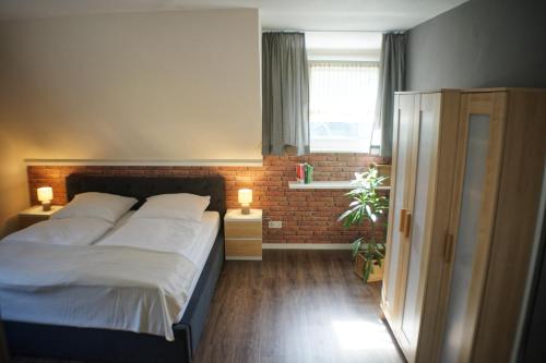 a bedroom with a bed and a brick wall at Ferienwohnungen Reinhilde - Litzig in Traben-Trarbach