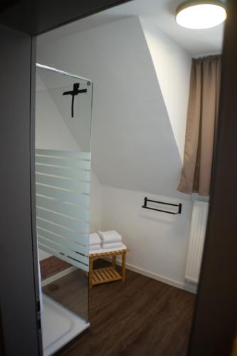 a bathroom with a glass shower with a stool at Ferienwohnungen Reinhilde - Litzig in Traben-Trarbach
