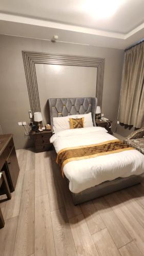 a bedroom with a large bed with a silver headboard at العنوان للشقق المخدومة ALanwaan of the units served in Dammam