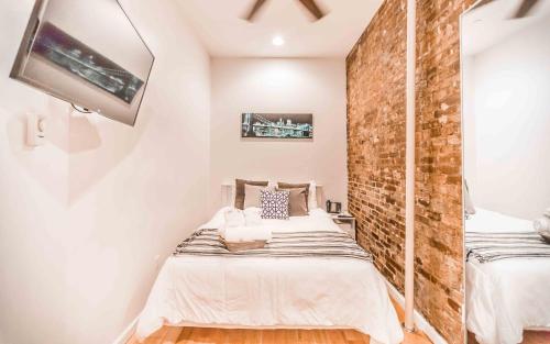 a bedroom with a bed and a brick wall at Chelsea Inn in New York