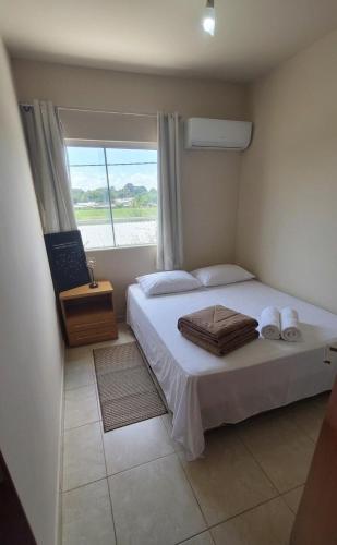 a bedroom with a large bed with a window at Apê estiloso e funcional no coração da cidade in Porto Velho