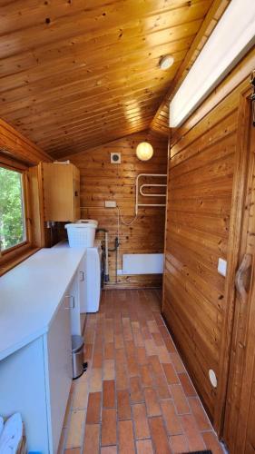 a kitchen with wooden walls and a tile floor at Swedish cottage near ocean in Norrtälje