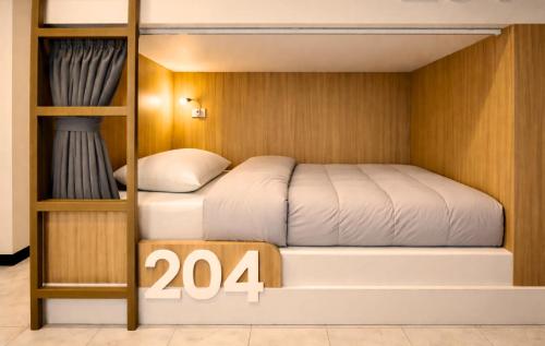 a bedroom with two bunk beds with a sign at KPOP Hostel in Karon Beach