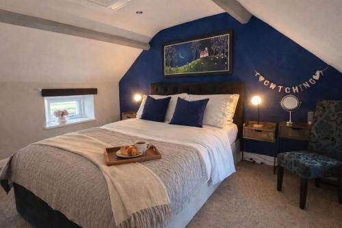 a bedroom with a large bed with a tray on it at Charming Shepherd's Cottage, Pets Welcome,Parking in Bridgend