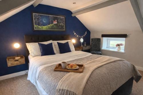 a bedroom with a large bed with a tray on it at Charming Shepherd's Cottage, Pets Welcome,Parking in Bridgend