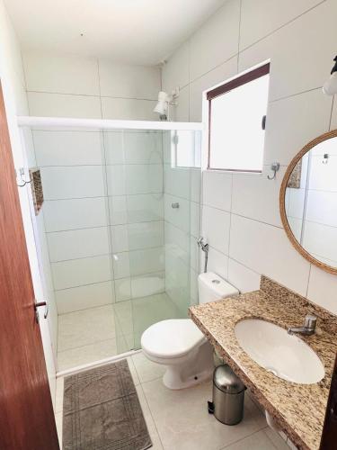 a bathroom with a toilet and a sink and a mirror at 4 Ventos House in São Miguel do Gostoso