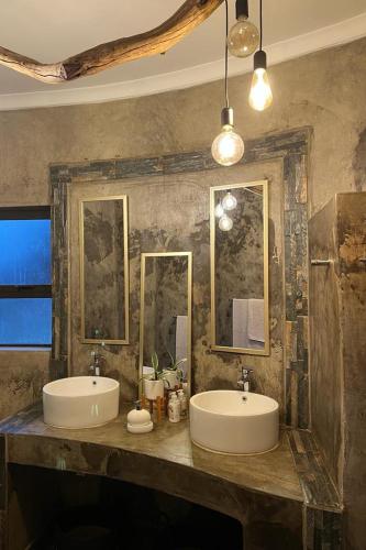 a bathroom with two sinks and two mirrors at Gamagara Africa Private Nature Reserve in Kathu