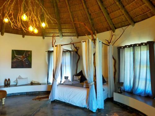 a bedroom with a bed in a room with windows at Gamagara Africa Private Nature Reserve in Kathu