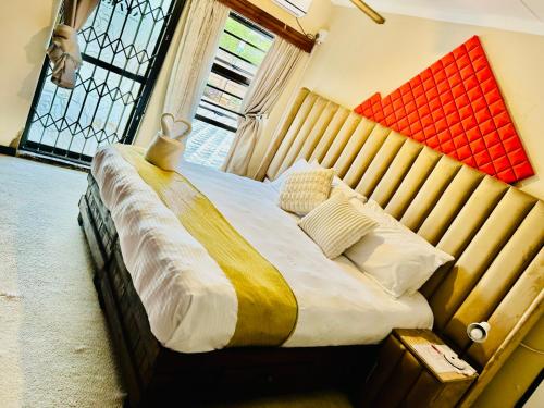 a bedroom with a large bed with a wooden headboard at SapzRes at Klerksdorp in Klerksdorp