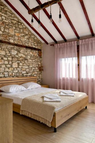 a bedroom with a large bed in a brick wall at Balis House in Theológos