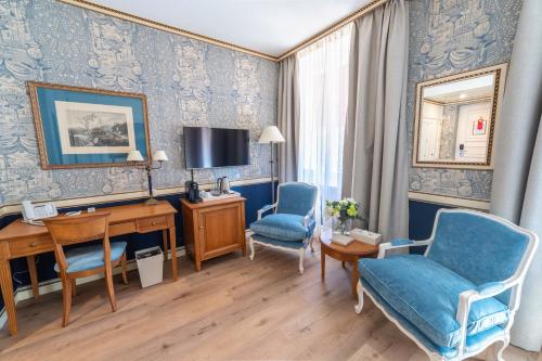 a room with a desk and two chairs and a tv at Carlton Lausanne Boutique Hôtel in Lausanne