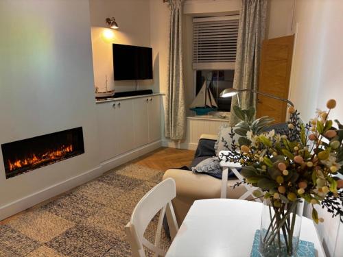 a living room with a couch and a fireplace at Ship Cottage Tenby Beach 50m in Pembrokeshire