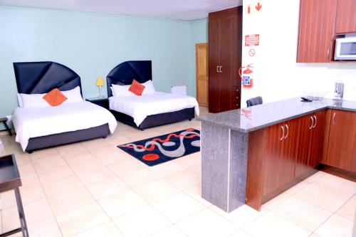 a hotel room with two beds and a kitchen at Grand View B&B in Johannesburg