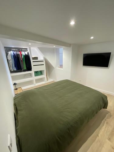 a bedroom with a bed and a flat screen tv at Belle escale by LV in Dieppe
