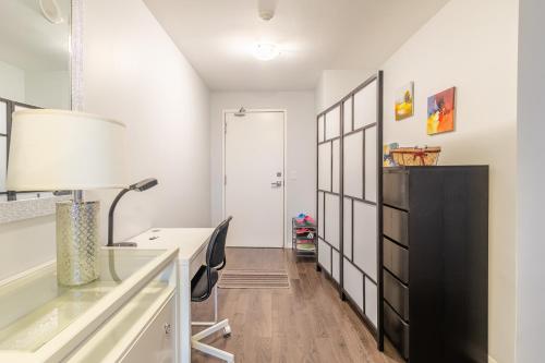 a room with a desk and a table with a lamp at Urban Explore in Toronto