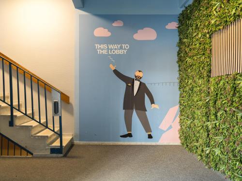 a painting of a man in a suit on a wall at HOTEL N Hostel Malmö City in Malmö