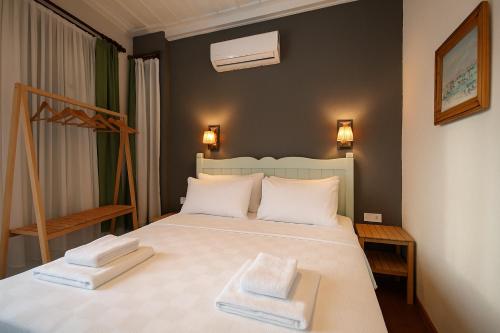 a bedroom with a bed with two towels on it at Defne Pansiyon Ayvalık in Ayvalık
